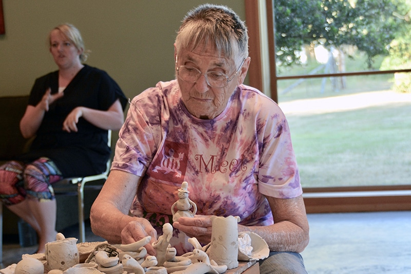 Elinor - preparing our pottery for glazing